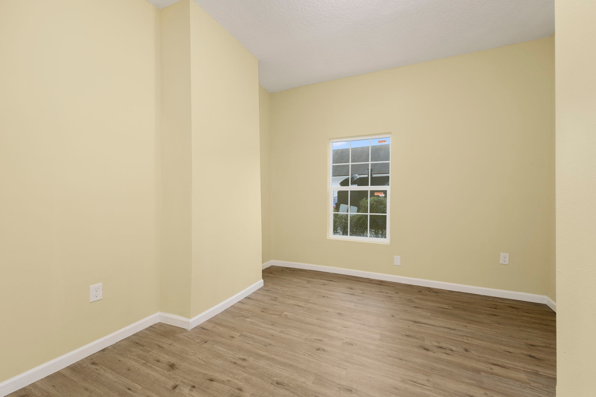 Bedroom with pale yellow walls, white trim and window