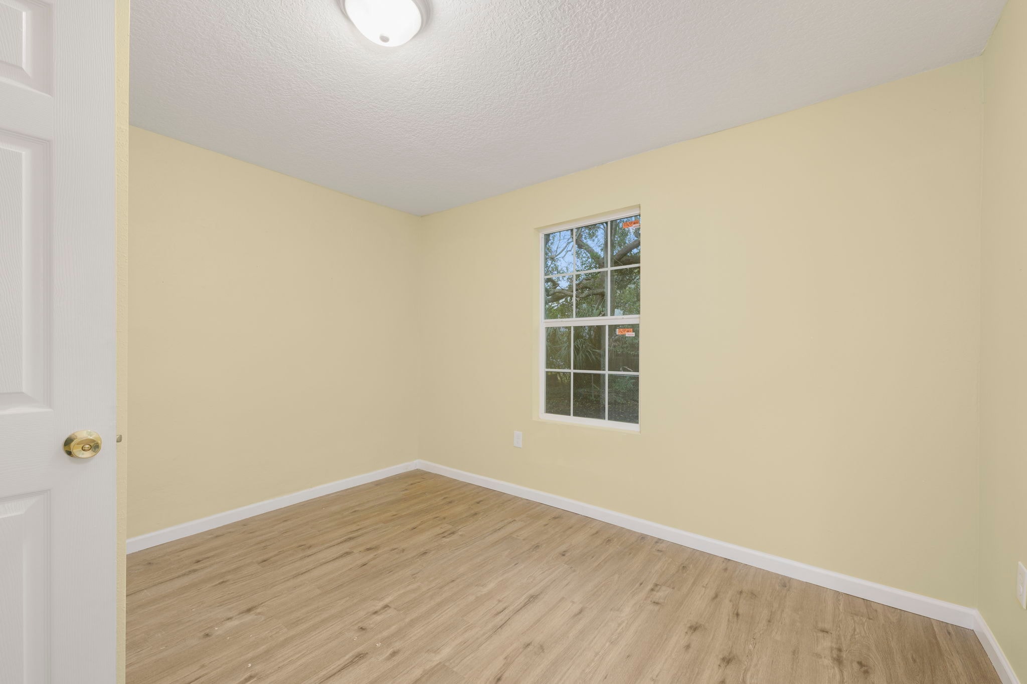 Bedroom with yellow walls, window and new hardwood floors