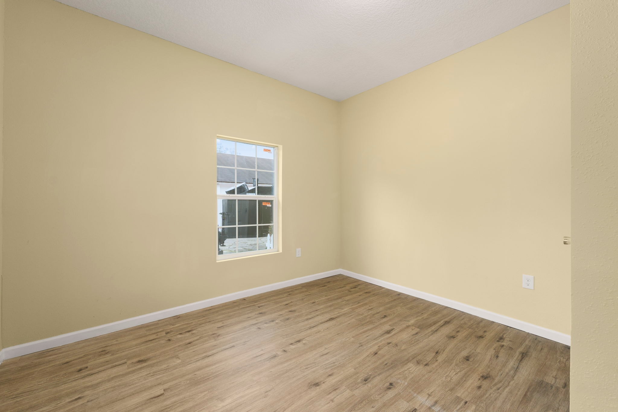 Bedroom with yellow walls and wood flooring