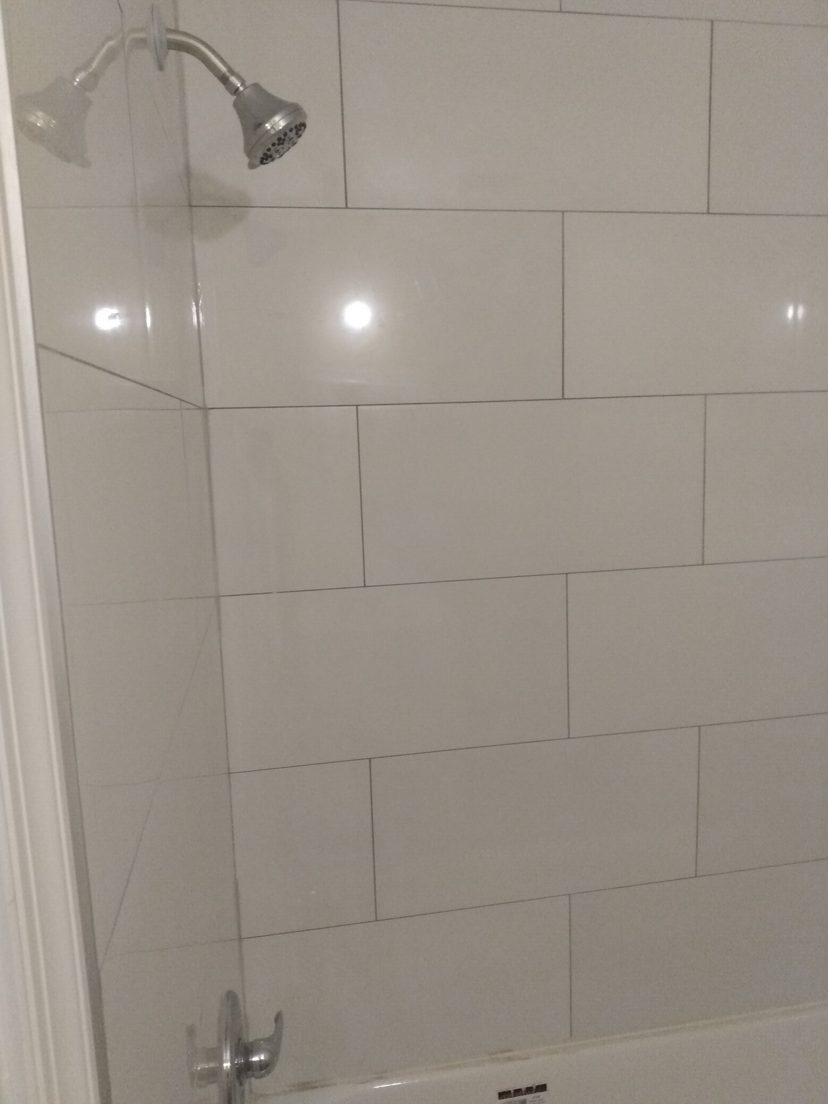 Shower/tub surround – large white subway tile, chrome shower head and fixtures