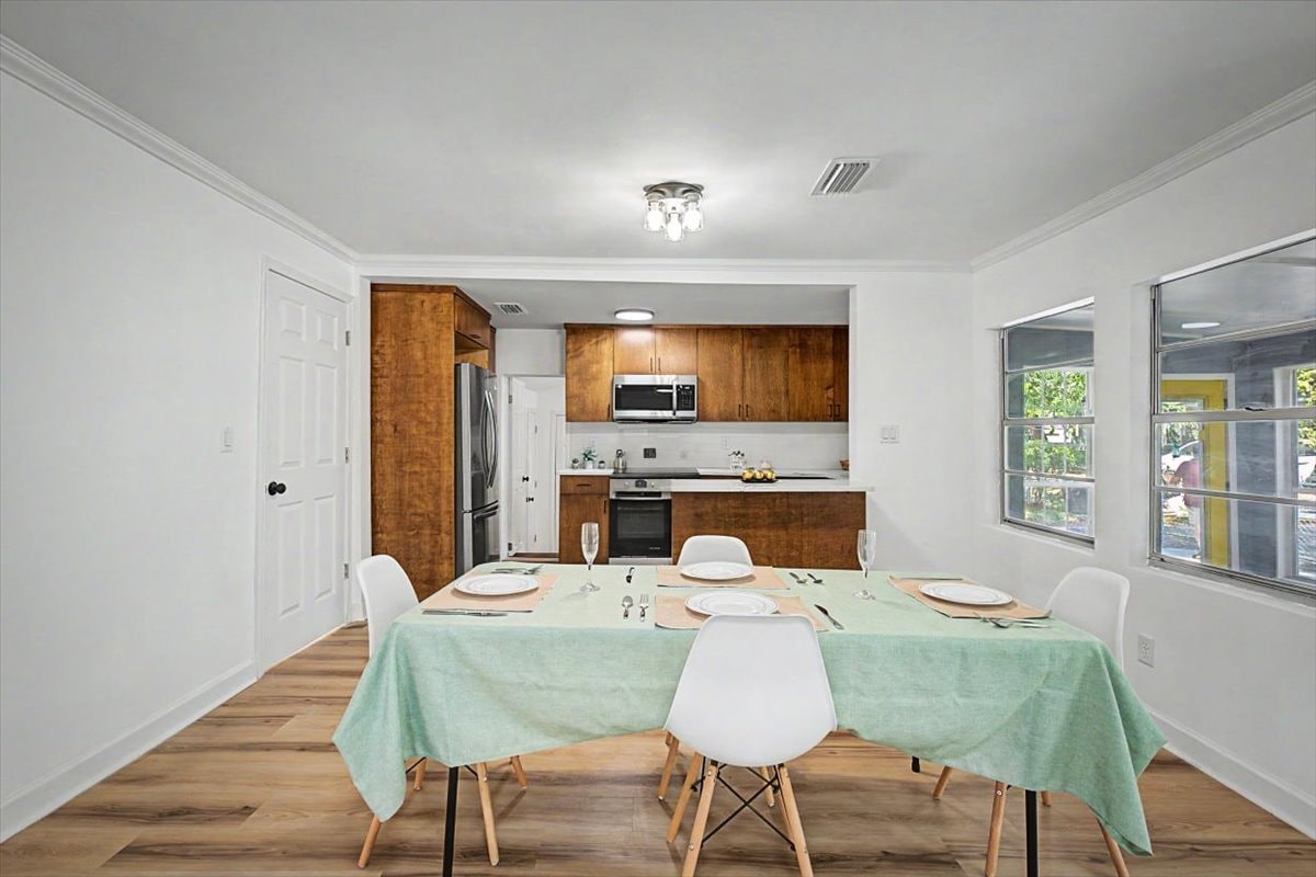 Dining area looking into kitchen – walnut cabinets, stainless appliances, white quartz countertops