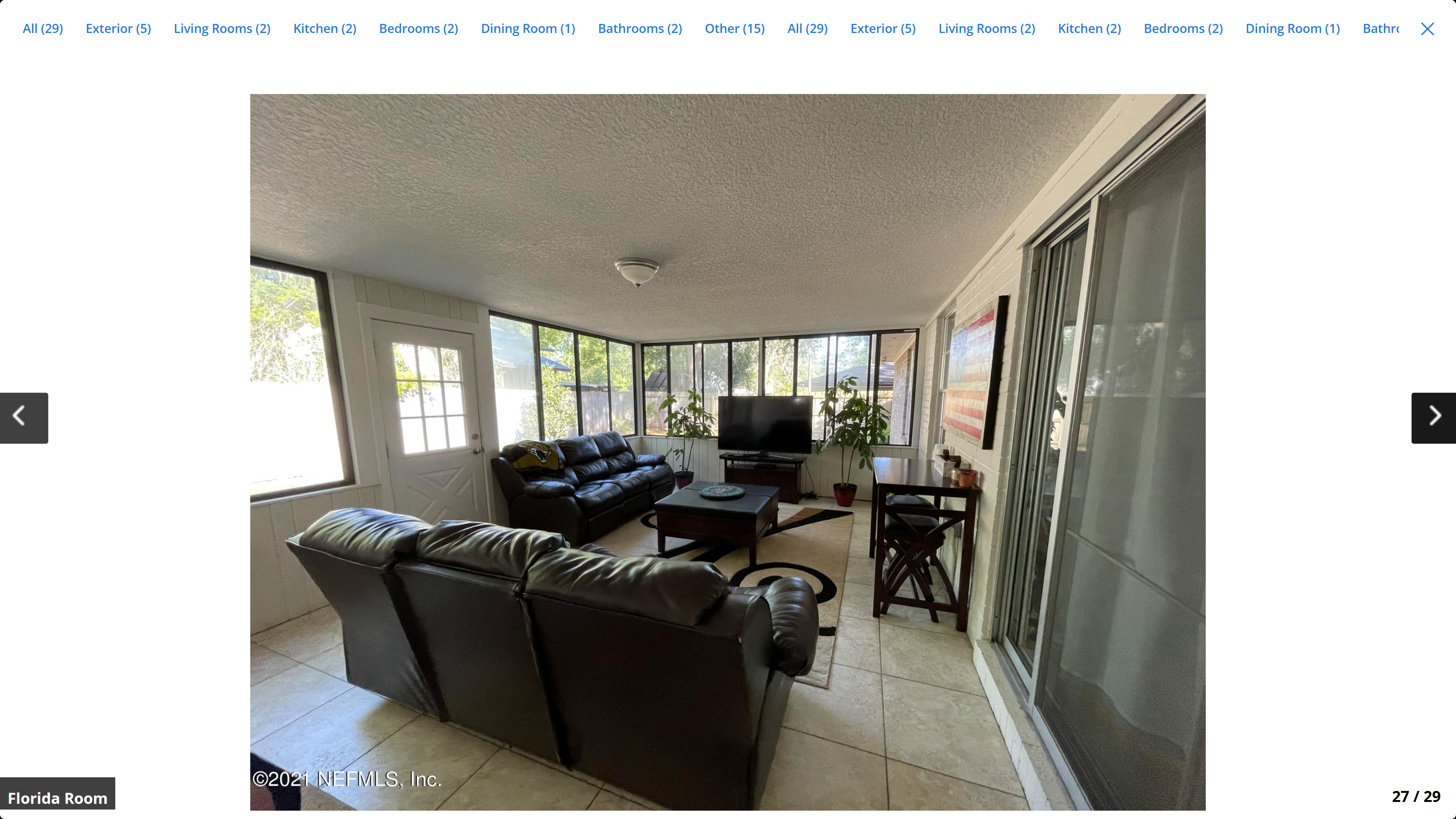 Florida room / sunroom – tile floor, wraparound windows, leather seating, sliding glass door to backyard