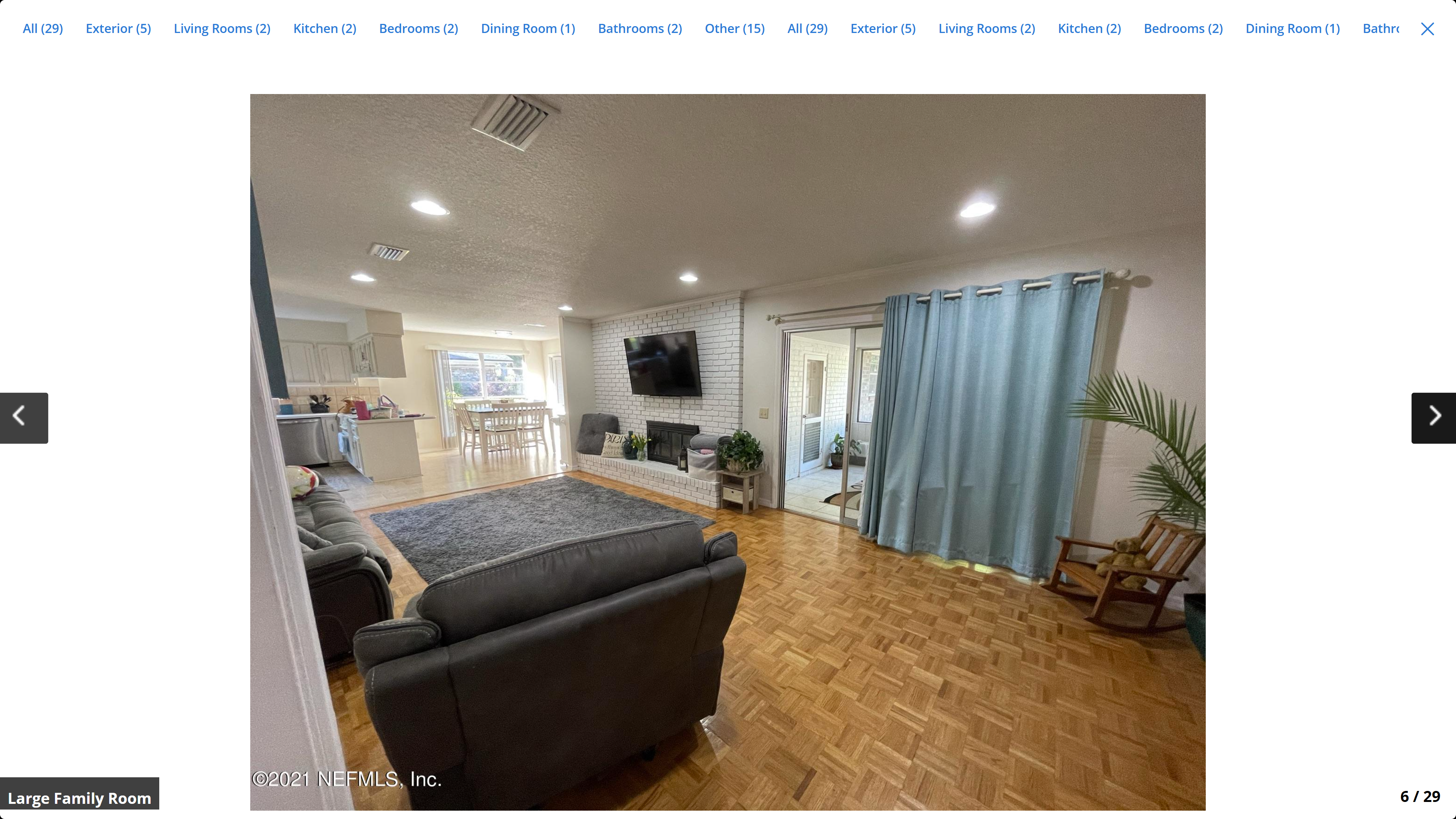 Large family room – parquet hardwood floors, white brick fireplace, open to kitchen and dining