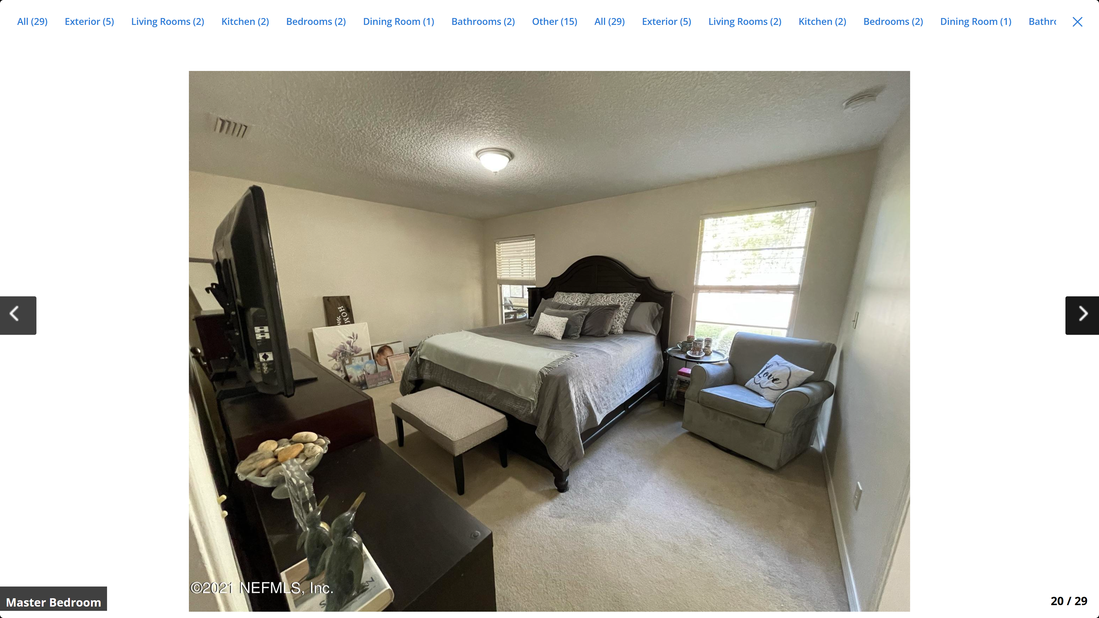 Master bedroom – carpet, two windows, sitting area with armchair
