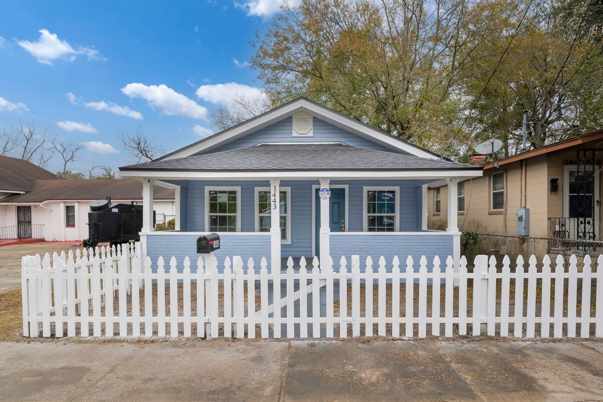 1443 W 22nd St – exterior front view, renovated blue and white cottage