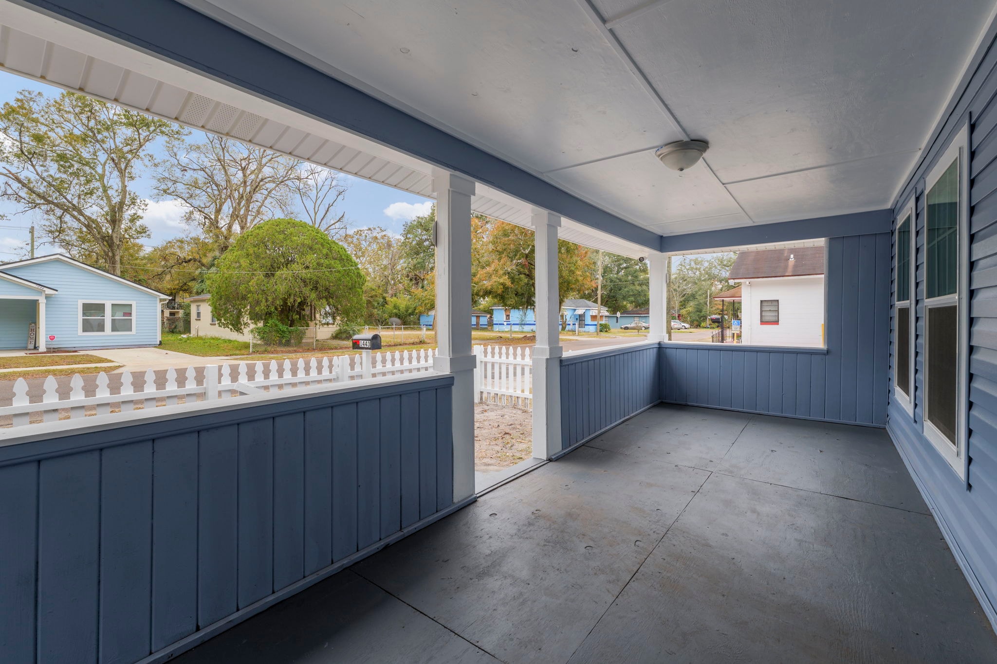 Covered front porch with dark blue wainscoting and white railings