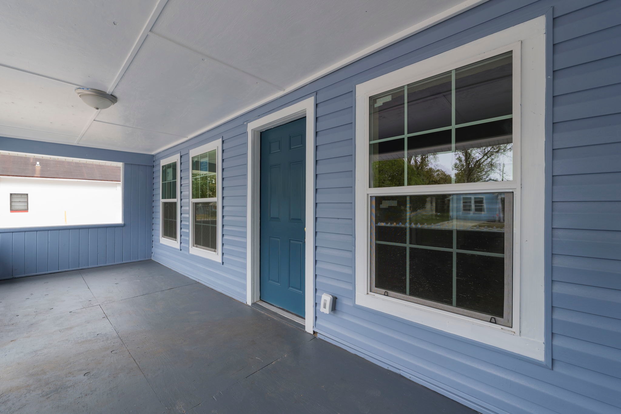 Porch detail – teal front door and white-trimmed windows