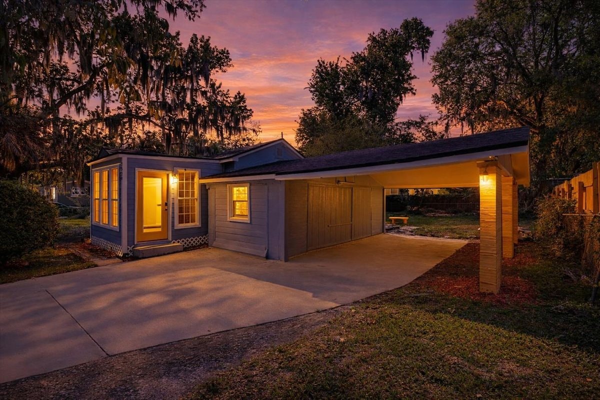 Virtual twilight exterior – warm interior lighting glows through windows at dusk under vivid sunset sky