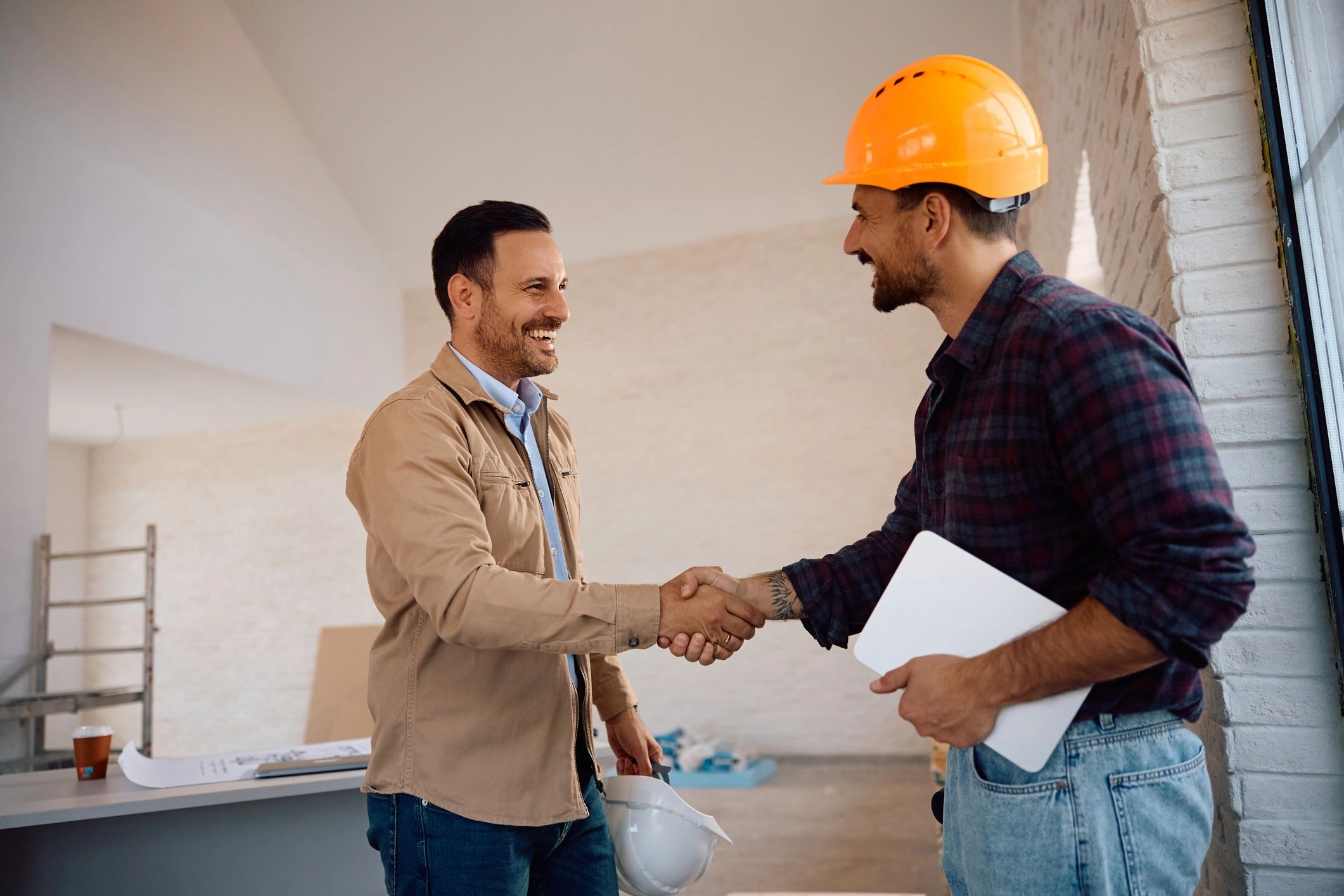 Two professionals shaking hands at a construction site